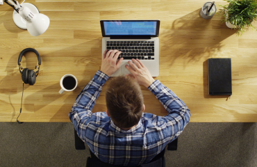 top-view-of-young-creative-man-working-on-his-laptop-beside-him-on-the-table-lies-notebook-and-headphones_rccs9mvue_thumbnail-full01